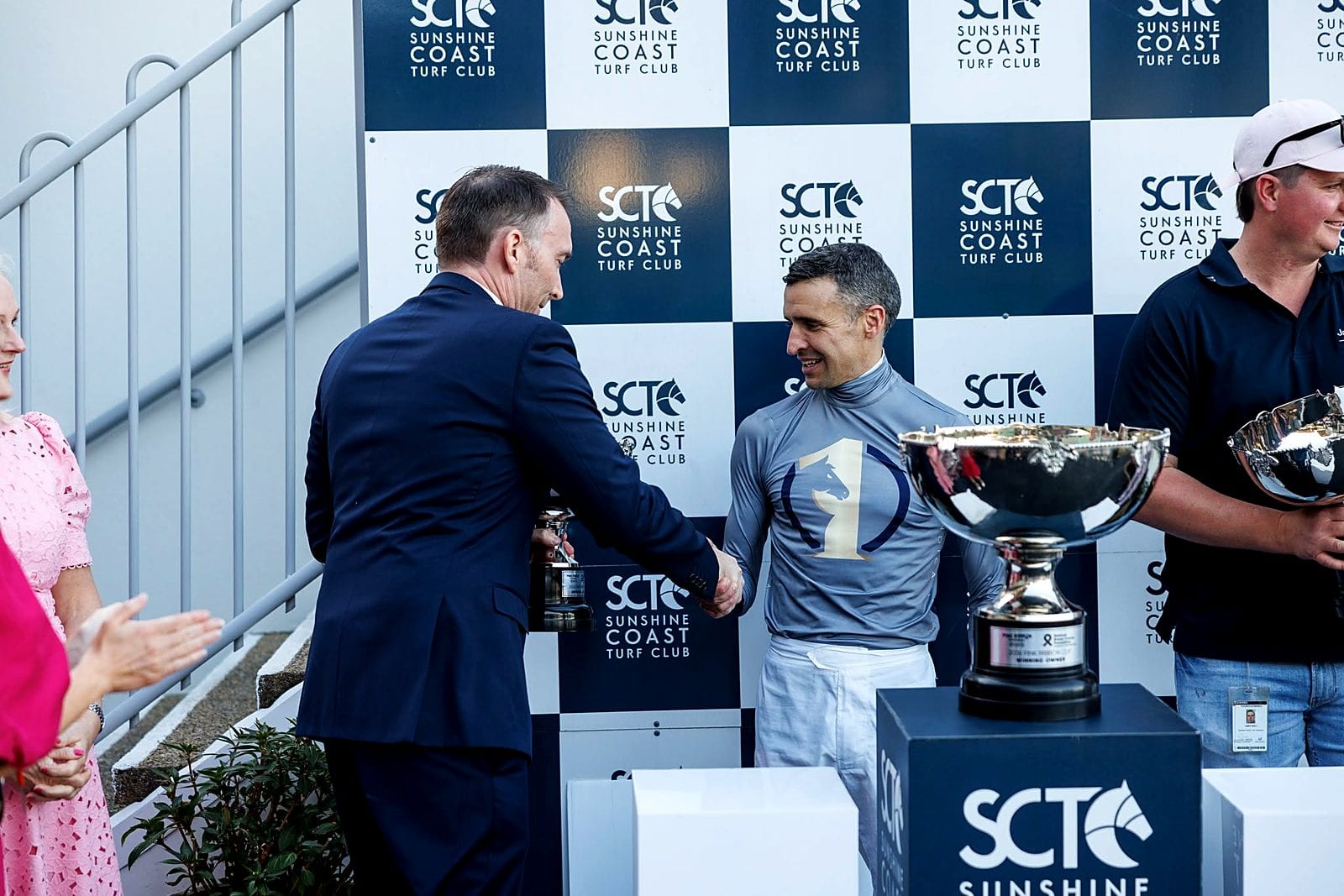 One Syndications jockey accepting the trophy at Sunshine Coast